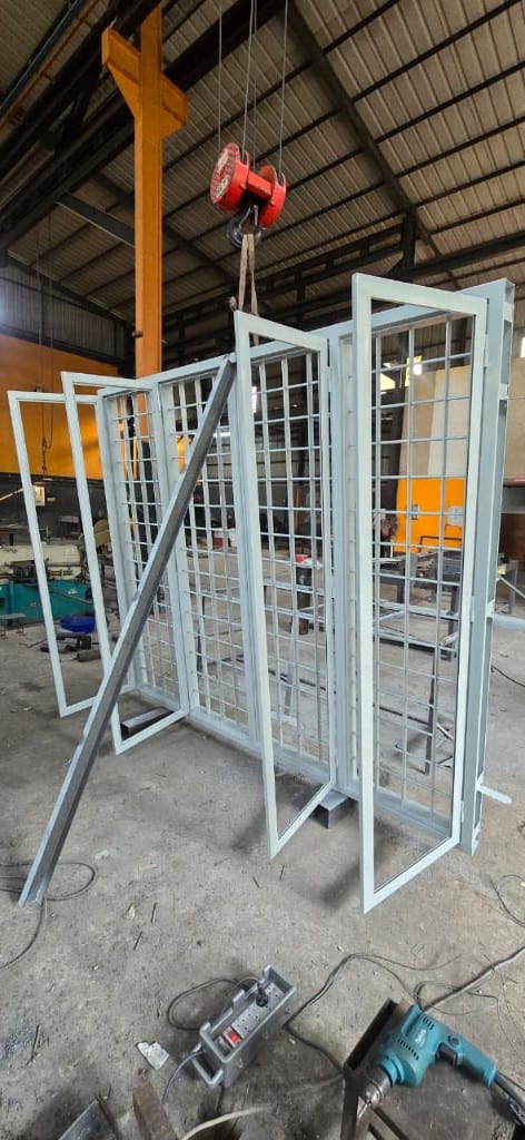 Grilled steel window frames lifted on the plant crane during fabrication
